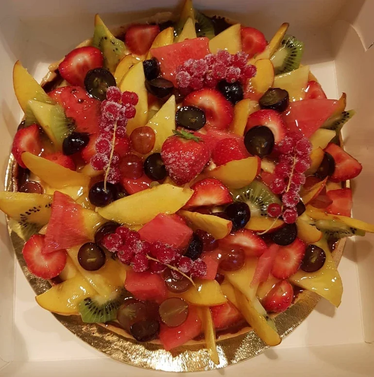 Fruittaart met aardbeien, mango, kiwi, druiven en rode bessen