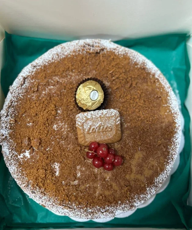 Taart met speculooscrumble, een Lotus-koekje, een Ferrero Rocher en rode bessen