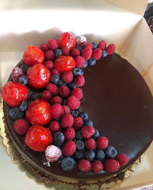 Chocoladetaart versierd met aardbeien, frambozen en bosbessen